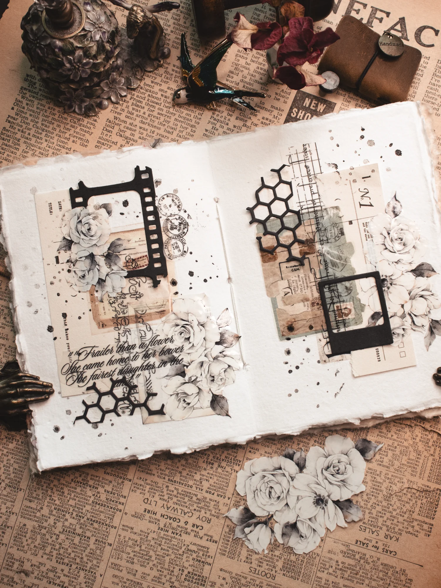 An open journal spread with expressive face sketches, dark floral cutouts, and handwritten details