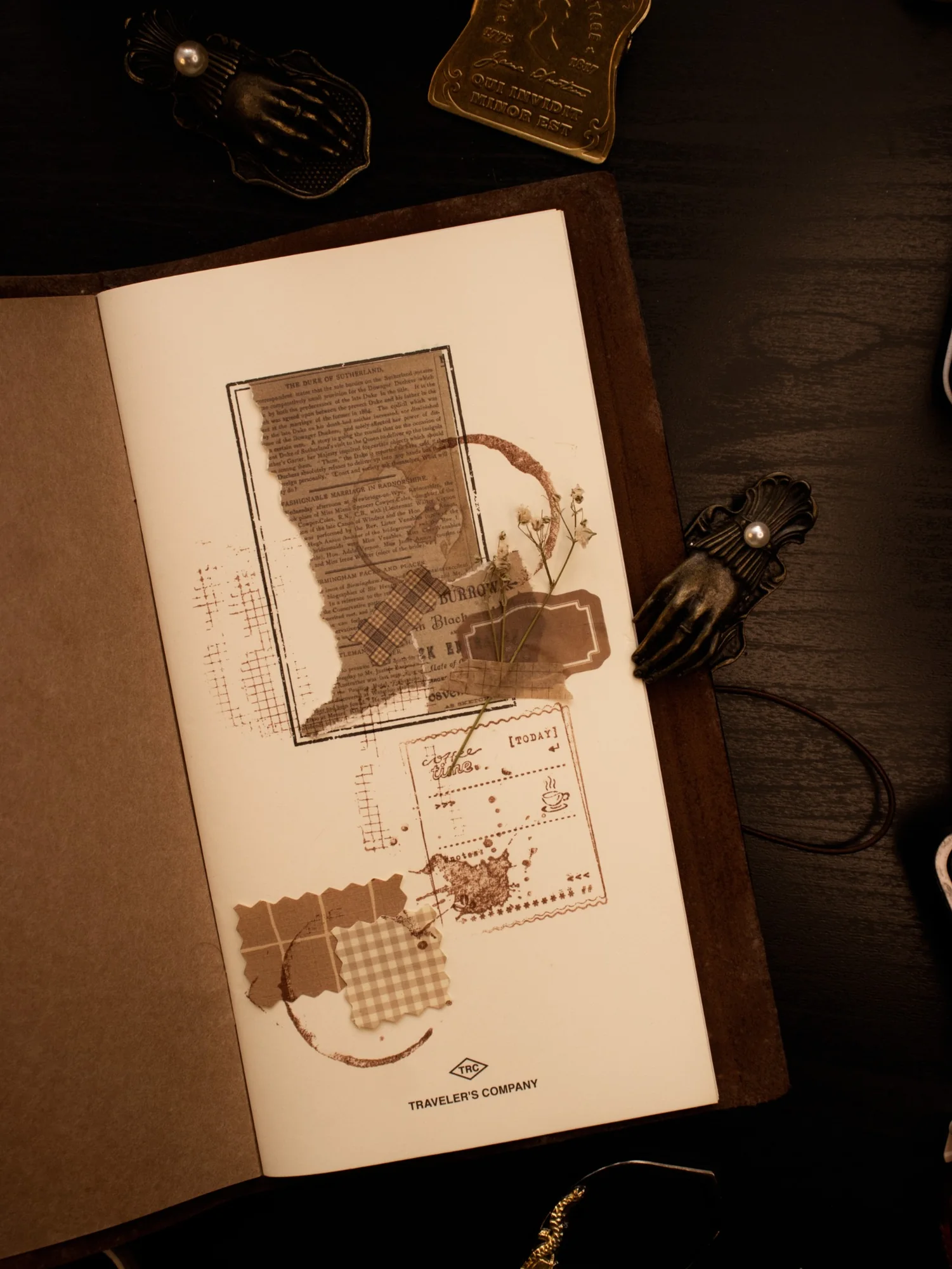 A cream journal page decorated with coffee stamps, brown paper pieces, and handwritten marks