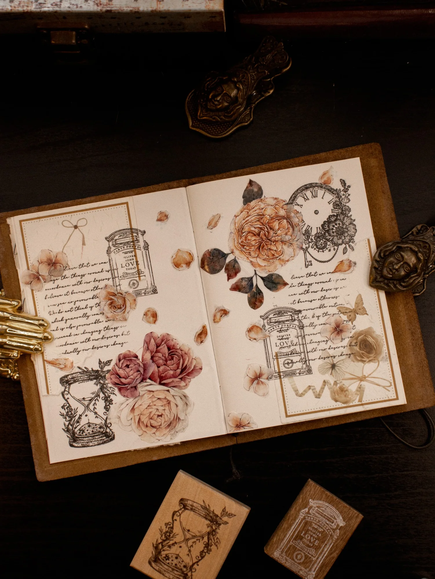 An open journal spread arranged with pink roses, vintage paper, and small keepsakes