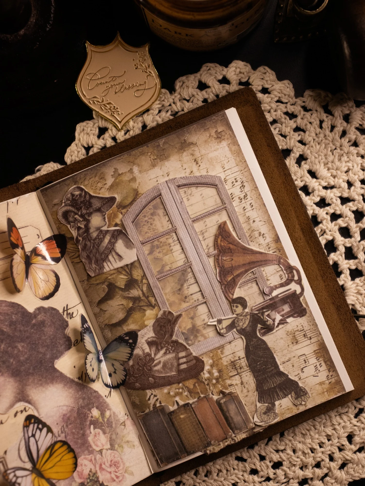 An open journal spread layered with old map fragments, photographs, and sepia paper